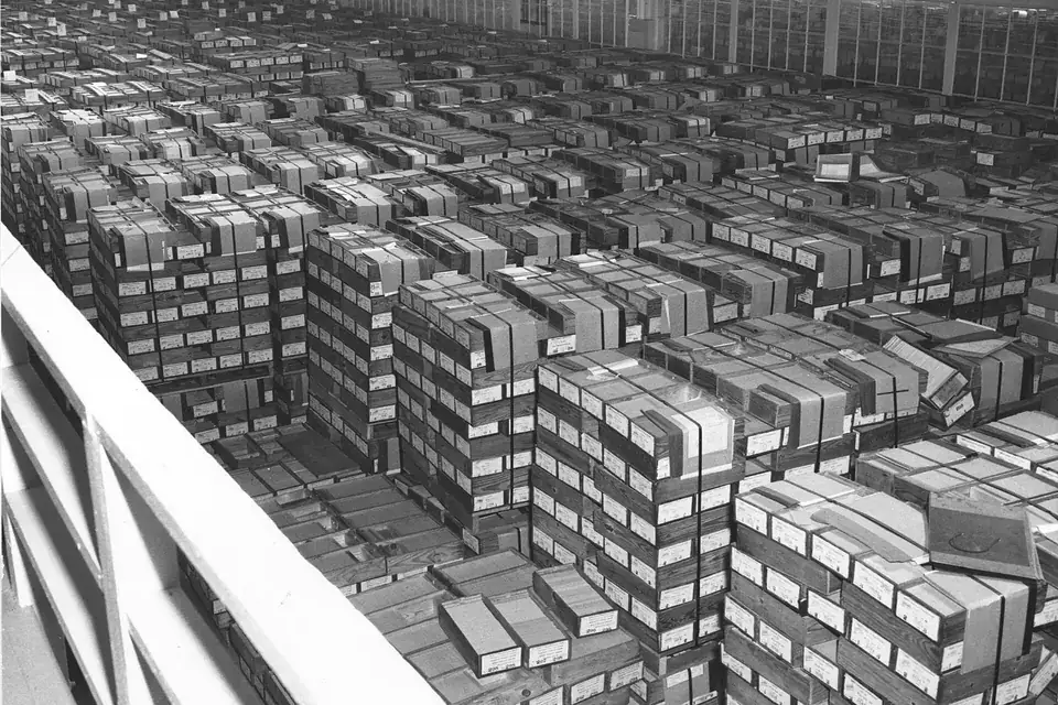 Rows upon rows of stacked boxes of punched record cards filling a large warehouse floor
